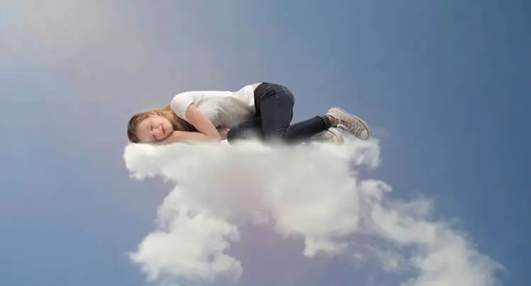Woman sleeping on cloud in dream