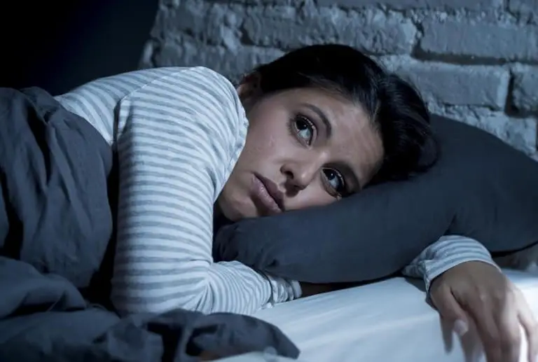 Woman in bed not wanting to lucid dream