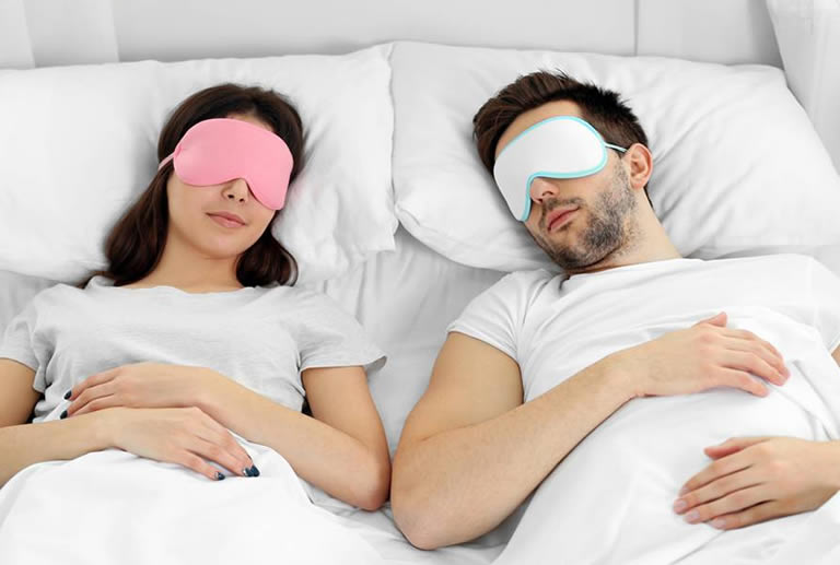 couple wearing lucid dream masks in bed