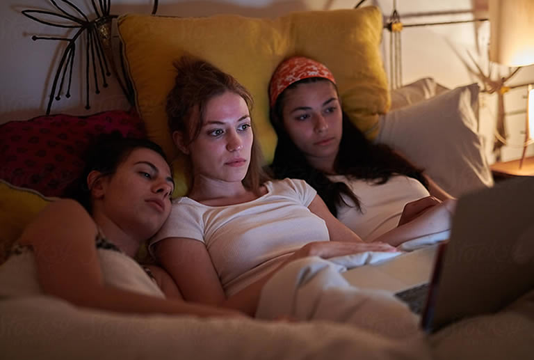 Women watching lucid dreaming video in bed